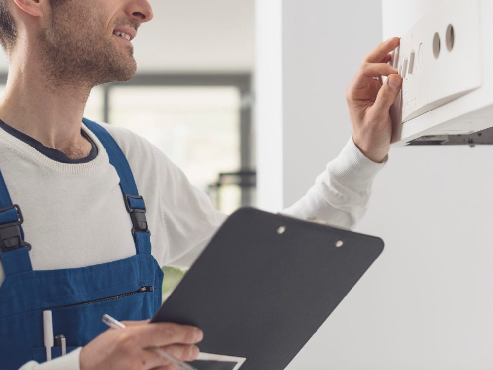 Professional plumber checking a boiler control panel, he is adjusting a knob